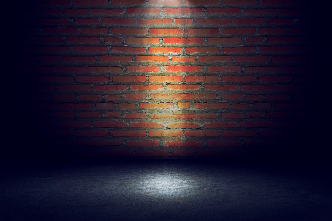 A streetlamp shining with a brick background